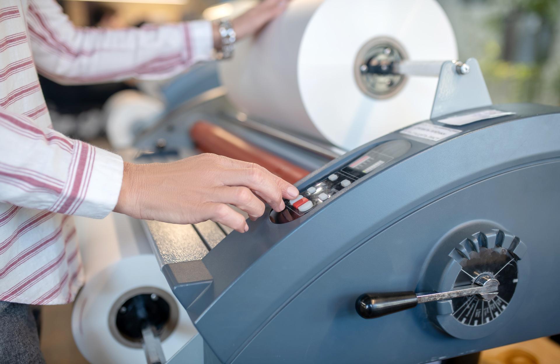 ScubaPrint, soluciones de estampación con transfers y herramientas en Gijón. Persona introduciendo un rollo en la impresora.